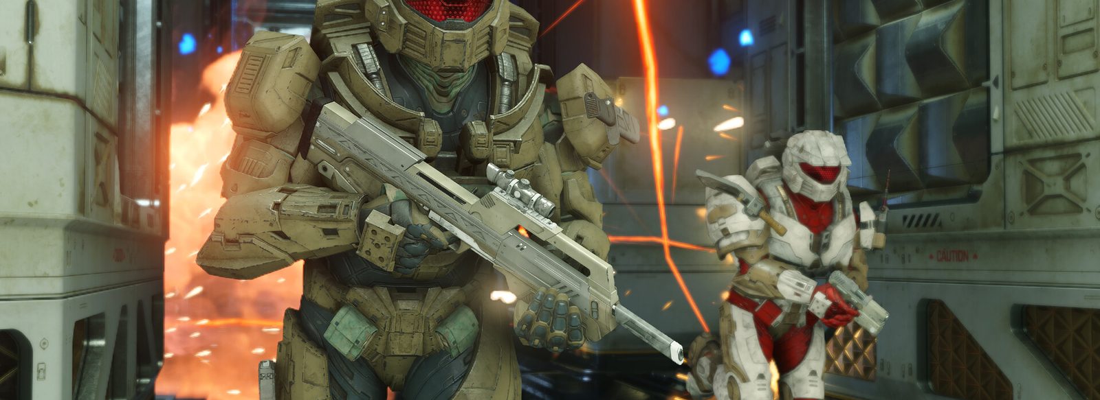 Halo Infinite screenshot: two armoured Spartans advancing through a base under fire